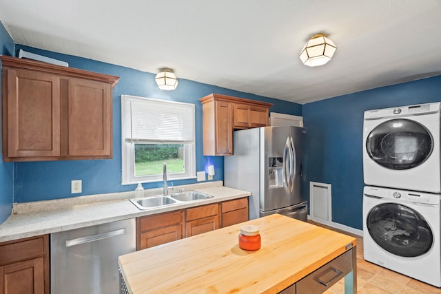 1305 Sims St, Columbia, MO 65201 - kitchen with appliances with stainless steel finishes, stacked washing machine and dryer, brown cabinetry, wooden counters, and light tile patterned flooring