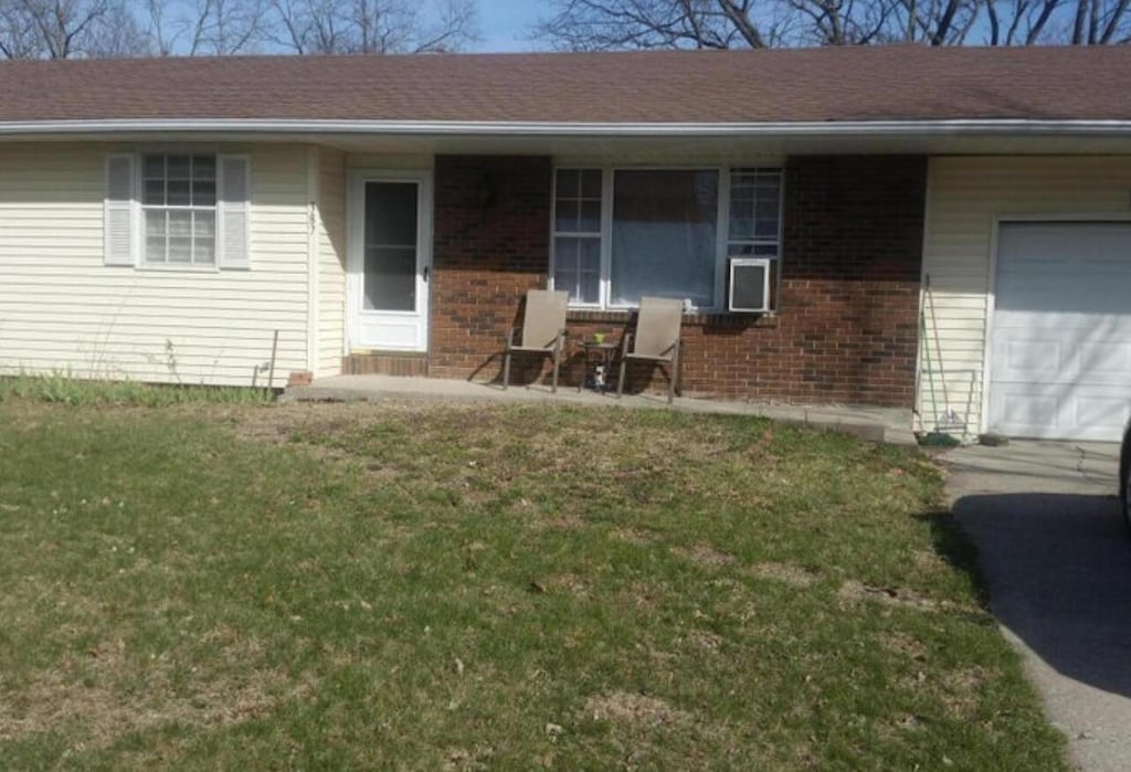 387 E Hackberry Blvd, Columbia, MO 65202 - entrance to property featuring an attached garage, brick siding, and a lawn