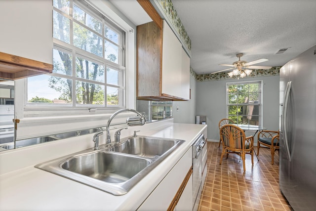 2710 Rollins Rd Unit A-1, Columbia, MO 65203 - kitchen with stainless steel appliances, a ceiling fan, light tile patterned floors, light countertops, and white cabinets