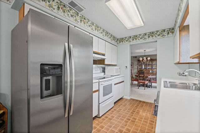 2710 Rollins Rd Unit A-1, Columbia, MO 65203 - kitchen featuring white appliances, light countertops, a chandelier, and white cabinets