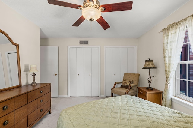 2710 Rollins Rd Unit A-1, Columbia, MO 65203 - bedroom with light colored carpet, two closets, and a ceiling fan