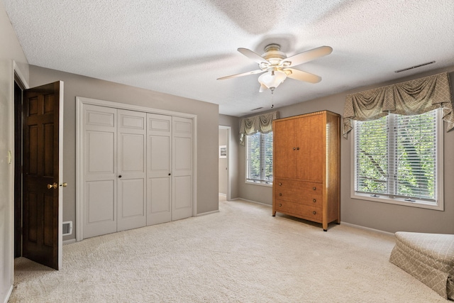 3707 Woodridge Ct, Columbia, MO 65201 - unfurnished bedroom featuring light colored carpet, a textured ceiling, ceiling fan, and a closet