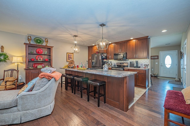 1331 Lantern Pointe Dr, Moberly, MO 65270 - kitchen featuring stainless steel appliances, a kitchen bar, wood finished floors, backsplash, and recessed lighting