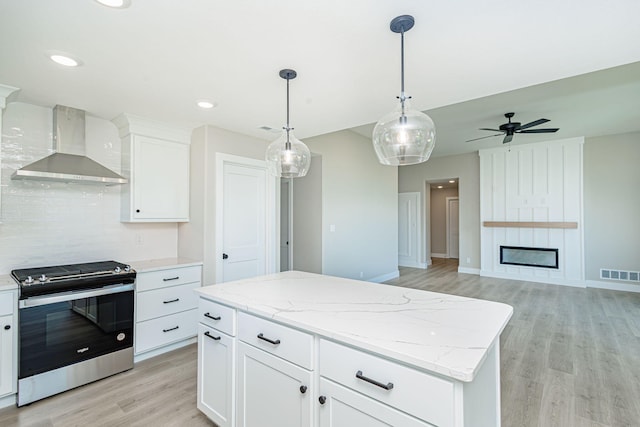 4512 Chambers Bay Dr, Columbia, MO 65201 - kitchen featuring stainless steel range oven, wall chimney exhaust hood, light wood-style flooring, decorative backsplash, and ceiling fan
