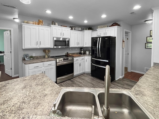 307 Jameson Dr, Ashland, MO 65010 - kitchen featuring stainless steel appliances, wood finished floors, white cabinets, recessed lighting, and light countertops