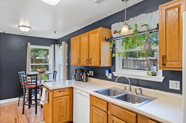 547 E Clearview Dr, Columbia, MO 65202 - kitchen with white dishwasher, a peninsula, light countertops, light wood-style flooring, and pendant lighting