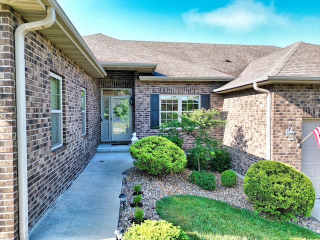 4106 Fritz Ct, Columbia, MO 65203 - view of exterior entry featuring brick siding, a shingled roof, and a garage