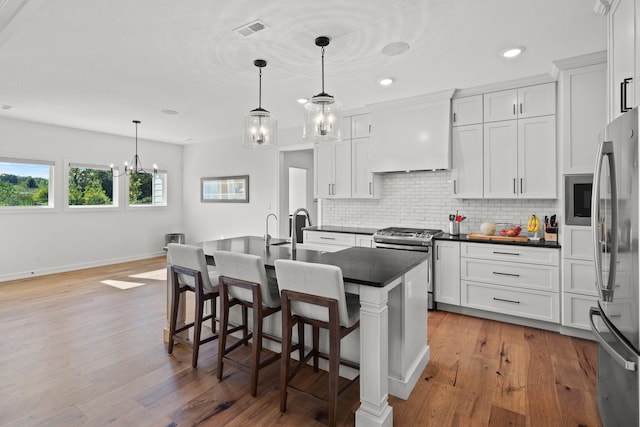 7405 Brackenhill Dr, Columbia, MO 65203 - kitchen featuring appliances with stainless steel finishes, dark countertops, premium range hood, decorative backsplash, and recessed lighting