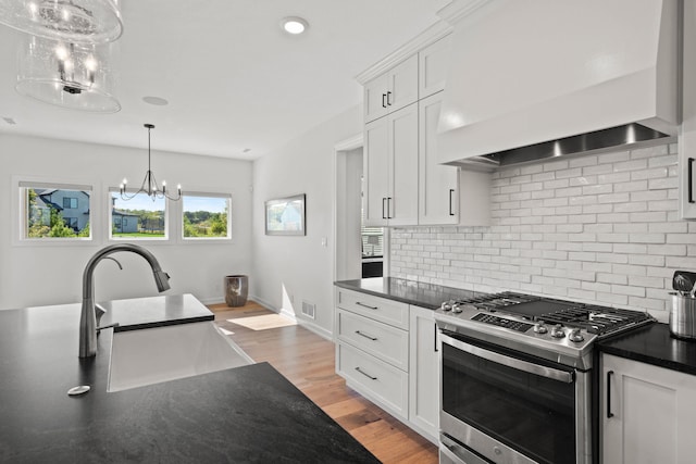 7405 Brackenhill Dr, Columbia, MO 65203 - kitchen featuring stainless steel gas range oven, custom range hood, a chandelier, backsplash, and white cabinets