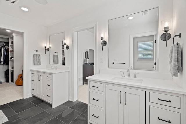 7405 Brackenhill Dr, Columbia, MO 65203 - bathroom featuring two vanities, a walk in closet, and recessed lighting
