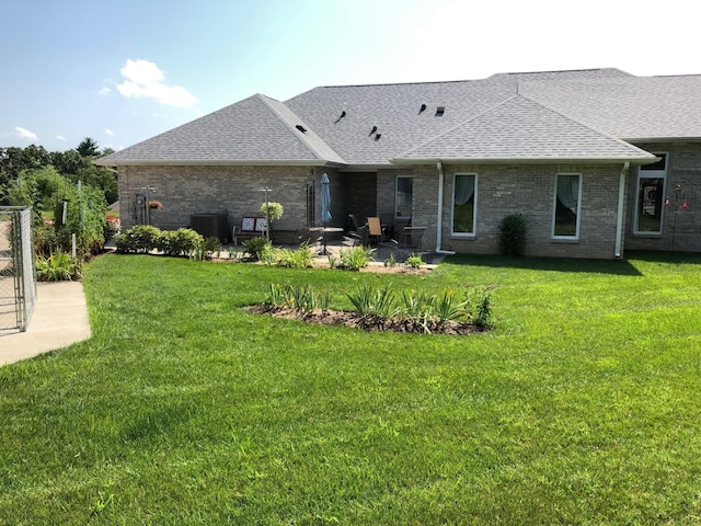 3824 Canyon Ridge Dr, Columbia, MO 65202 - rear view of property featuring roof with shingles, a patio area, brick siding, and a lawn