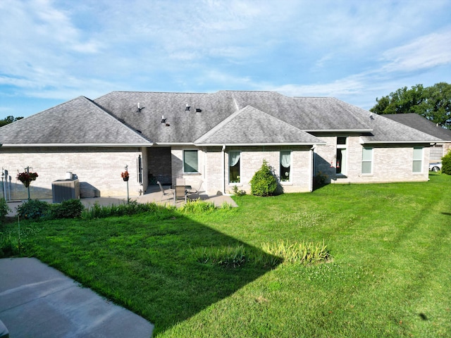 3824 Canyon Ridge Dr, Columbia, MO 65202 - back of property featuring a shingled roof, a patio area, brick siding, and a lawn