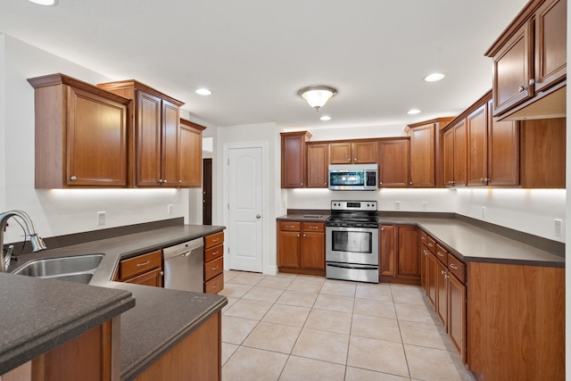 3106 Crabapple Ln, Columbia, MO 65203 - kitchen featuring stainless steel appliances, dark countertops, light tile patterned floors, brown cabinetry, and recessed lighting