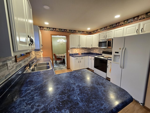 7951 N Marigold Ct, Columbia, MO 65202 - kitchen featuring white appliances, a chandelier, tasteful backsplash, dark countertops, and recessed lighting