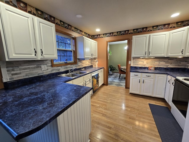 7951 N Marigold Ct, Columbia, MO 65202 - kitchen featuring electric range, decorative backsplash, dark countertops, white cabinets, and light wood finished floors