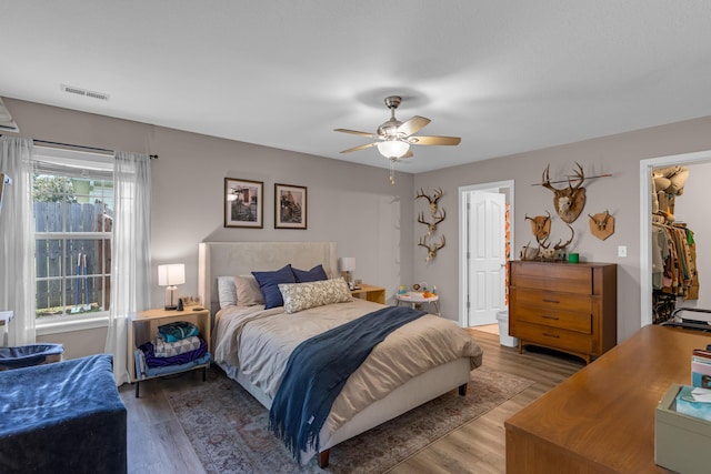 3810 Crocodile Dr, Columbia, MO 65202 - bedroom featuring wood finished floors, a spacious closet, a ceiling fan, and a closet
