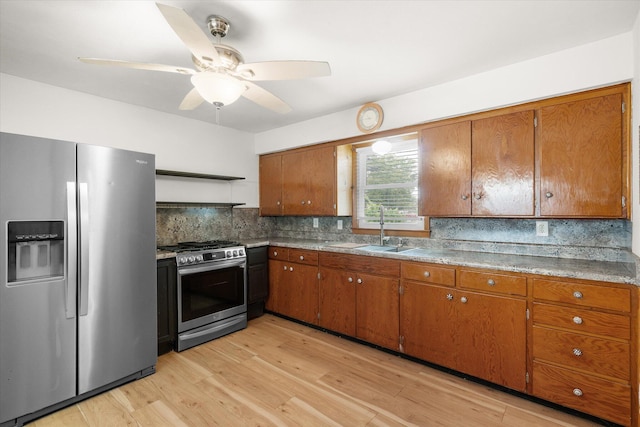 201 Ruby Ln, Columbia, MO 65203 - kitchen with appliances with stainless steel finishes, brown cabinetry, light wood-style floors, and decorative backsplash