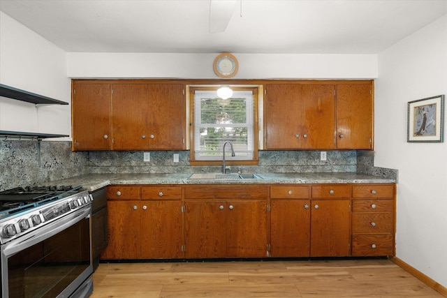 201 Ruby Ln, Columbia, MO 65203 - kitchen with gas range, brown cabinets, light wood finished floors, and backsplash