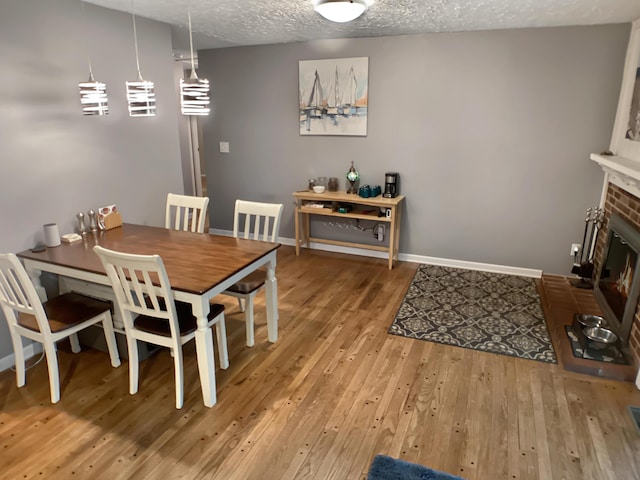 113 E El Cortez Dr, Columbia, MO 65203 - dining space featuring hardwood / wood-style flooring, a fireplace, and a textured ceiling