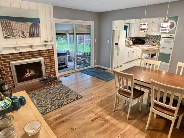 113 E El Cortez Dr, Columbia, MO 65203 - dining space with light wood finished floors and a fireplace