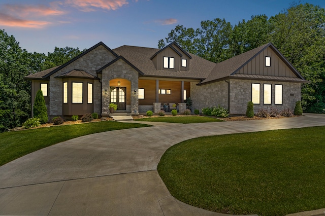 1880 W Cresskill Dr, Columbia, MO 65203 - view of front of property featuring stone siding, a standing seam roof, a lawn, and curved driveway
