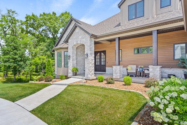 1880 W Cresskill Dr, Columbia, MO 65203 - view of front of property with covered porch, stone siding, a front yard, board and batten siding, and a shingled roof