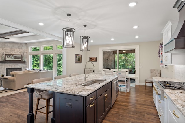 1880 W Cresskill Dr, Columbia, MO 65203 - kitchen featuring stainless steel appliances, a kitchen bar, light stone counters, dark wood-style floors, and white cabinetry