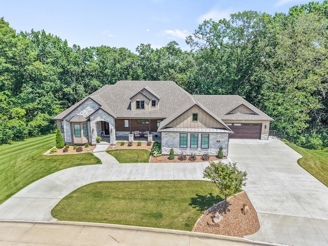 1880 W Cresskill Dr, Columbia, MO 65203 - view of front of home with stone siding, concrete driveway, a front lawn, board and batten siding, and roof with shingles