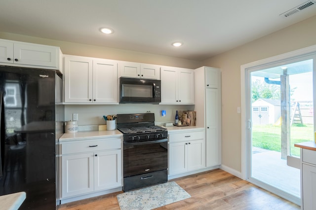 717 S Central St, Centralia, MO 65240 - kitchen with black appliances, light countertops, light wood-style flooring, white cabinets, and recessed lighting