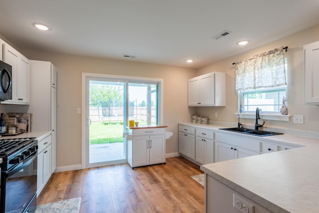 717 S Central St, Centralia, MO 65240 - kitchen featuring black appliances, light wood finished floors, plenty of natural light, light countertops, and recessed lighting