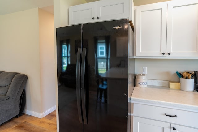 717 S Central St, Centralia, MO 65240 - kitchen featuring freestanding refrigerator, light wood-style flooring, white cabinets, and light stone counters