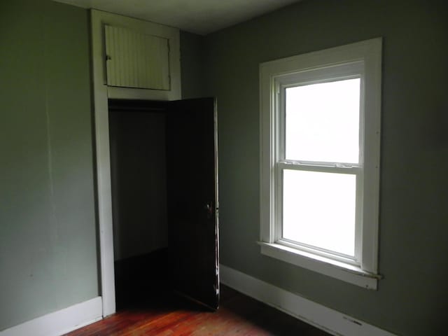 205 W Harrison St, Farber, MO 63345 - unfurnished bedroom featuring multiple windows and dark wood-style flooring