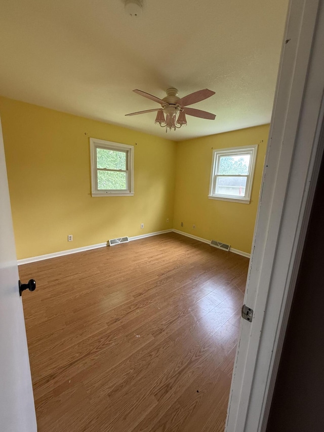 2220 N Lakeland Dr, Columbia, MO 65202 - spare room with healthy amount of natural light, wood finished floors, ceiling fan, and a smoke detector