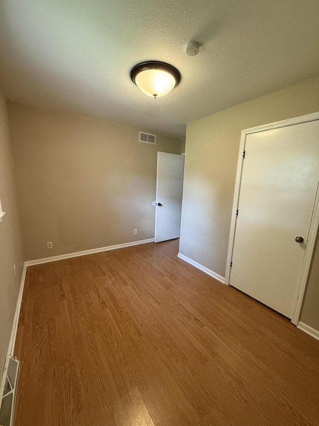2220 N Lakeland Dr, Columbia, MO 65202 - unfurnished room with wood finished floors, a textured ceiling, and a smoke detector