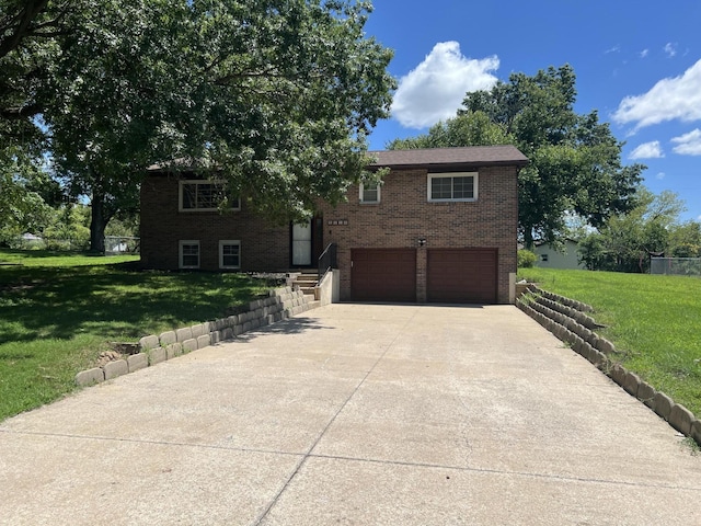 2220 N Lakeland Dr, Columbia, MO 65202 - split foyer home with an attached garage, concrete driveway, brick siding, and a front lawn