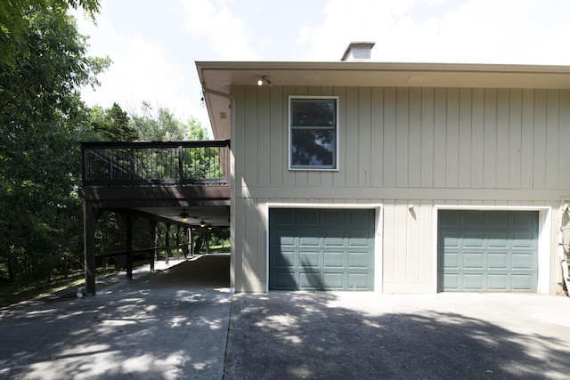6303 S Old Village Rd, Columbia, MO 65203 - view of side of home with driveway, a wooden deck, and a chimney