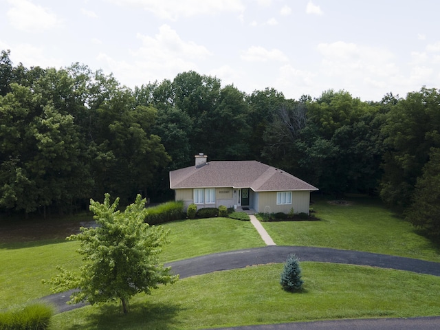 6303 S Old Village Rd, Columbia, MO 65203 - ranch-style house with a front yard, a chimney, a forest view, and driveway
