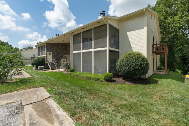 706 Park Deville Pl, Columbia, MO 65203 - back of house with a sunroom, a chimney, a lawn, and stairs