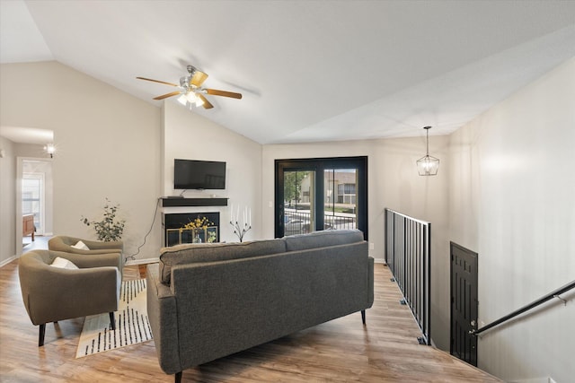 706 Park Deville Pl, Columbia, MO 65203 - living room with vaulted ceiling, a glass covered fireplace, light wood-type flooring, and a ceiling fan