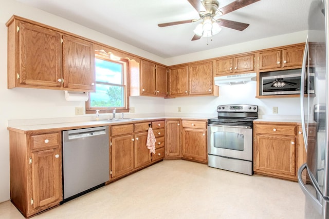 11657 Fletcher Ln, Holts Summit, MO 65043 - kitchen with stainless steel appliances, under cabinet range hood, light countertops, a ceiling fan, and brown cabinetry