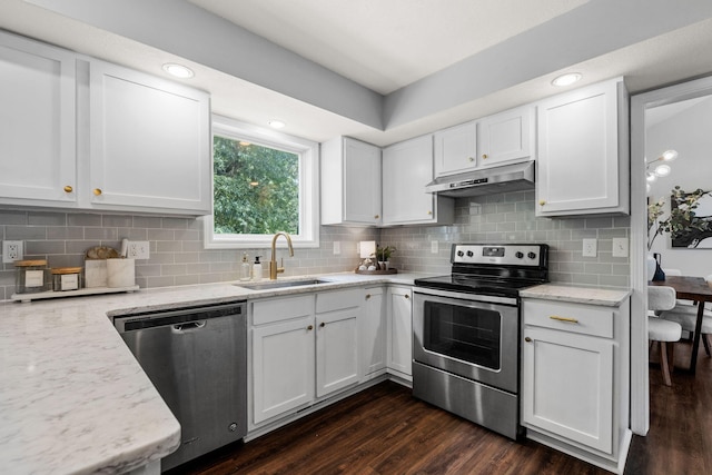 3712 Godfrey Dr, Columbia, MO 65203 - kitchen featuring appliances with stainless steel finishes, under cabinet range hood, white cabinetry, dark wood-style floors, and tasteful backsplash