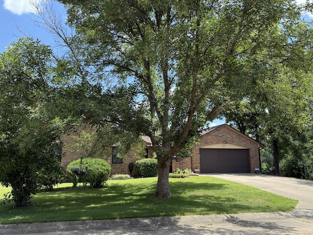 1620 S Berkley Dr, Columbia, MO 65201 - view of property hidden behind natural elements with brick siding, concrete driveway, a front lawn, and an attached garage
