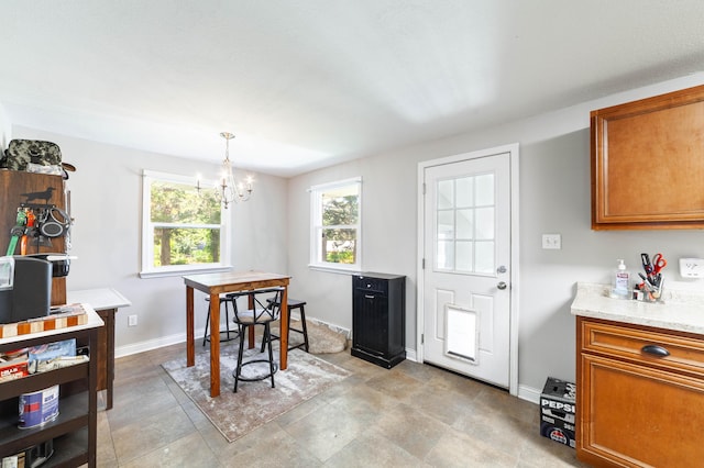 1601 Parklawn Ct, Columbia, MO 65202 - kitchen with brown cabinetry, a chandelier, light countertops, and pendant lighting