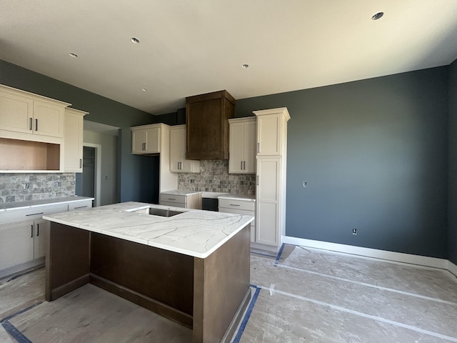 913 Spyglass Ct, Columbia, MO 65201 - kitchen with a kitchen island, decorative backsplash, white cabinetry, and light stone counters