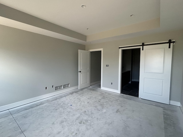 913 Spyglass Ct, Columbia, MO 65201 - unfurnished bedroom featuring a barn door, a raised ceiling, and concrete floors