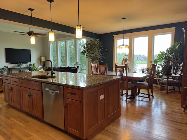 7930 S Ginn Ln, Columbia, MO 65201 - kitchen with stainless steel dishwasher, brown cabinets, healthy amount of natural light, and light wood-style flooring