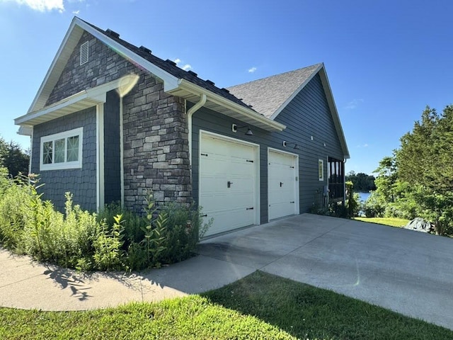 7930 S Ginn Ln, Columbia, MO 65201 - view of side of home featuring stone siding, a garage, and concrete driveway