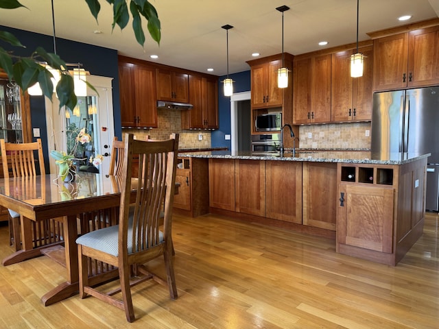 7930 S Ginn Ln, Columbia, MO 65201 - kitchen with stainless steel appliances, brown cabinets, decorative backsplash, light wood-type flooring, and recessed lighting