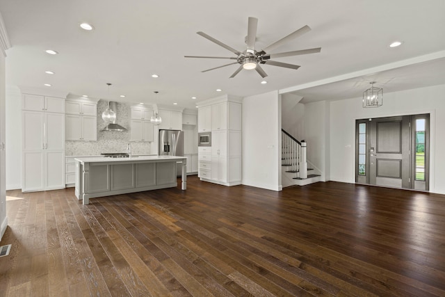 3001 Rivington Dr, Columbia, MO 65203 - kitchen featuring wall chimney exhaust hood, dark wood finished floors, appliances with stainless steel finishes, light countertops, and decorative backsplash