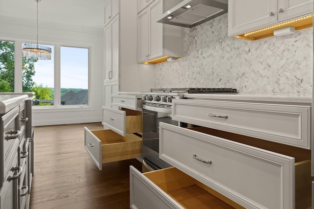 3001 Rivington Dr, Columbia, MO 65203 - kitchen featuring wall chimney range hood, stainless steel range with gas stovetop, dark wood finished floors, backsplash, and a chandelier